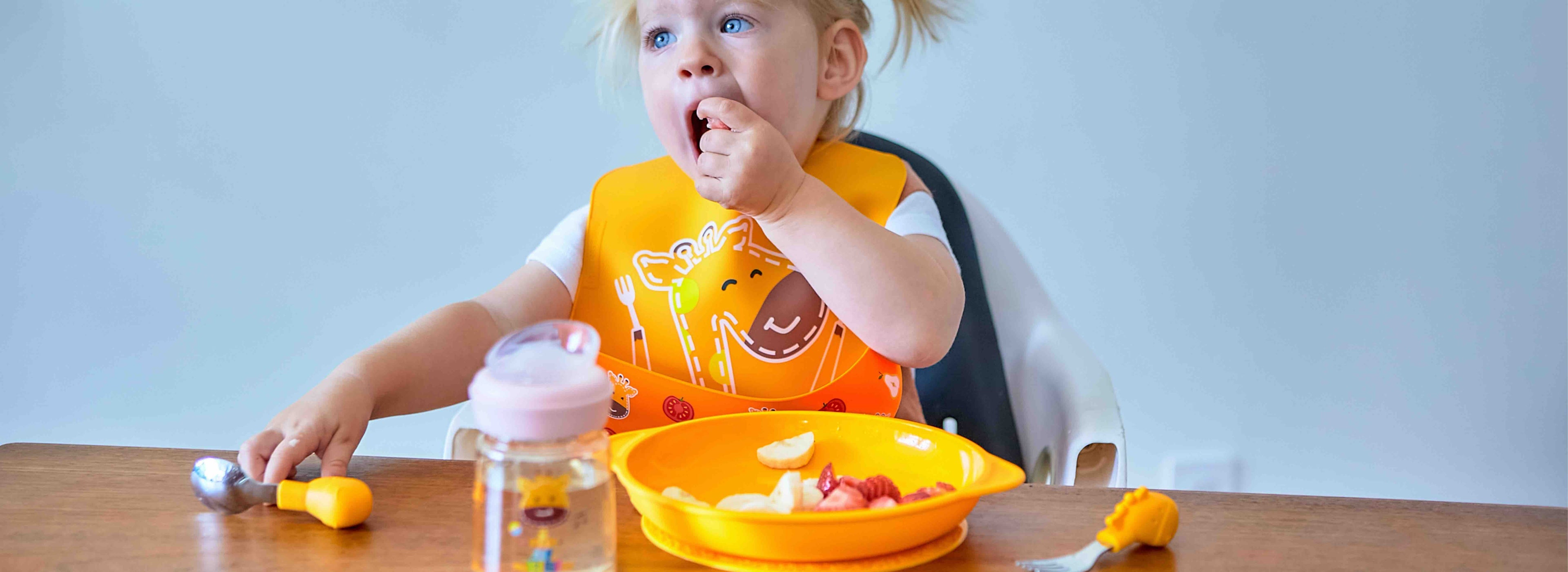 Toddler feeding with silicone bib plate and utensils for safe mealtime